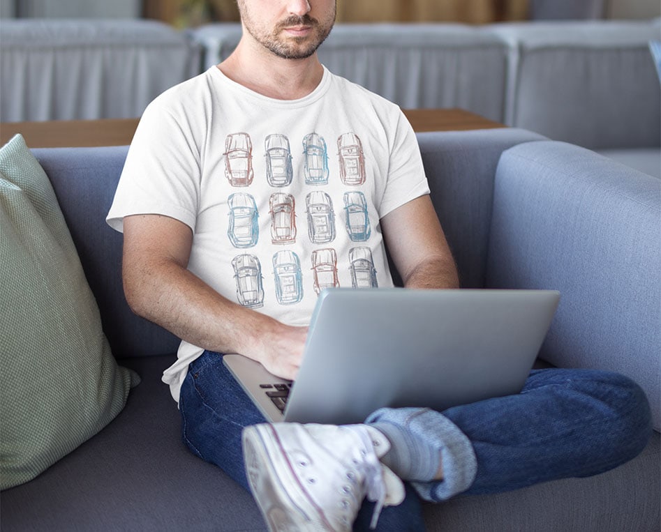 serious-white-man-wearing-a-t-shirt-mockup-working-with-his-laptop-on-a-sofa-a20437